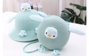 Detail of mint green penguin straw sun hat and matching crossbody bag for children