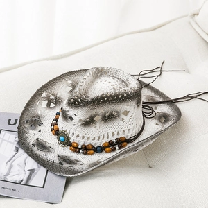 Western style white straw cowboy hat with turquoise bead band on a minimalist sofa