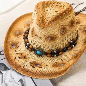 Detail of western straw cowboy hat featuring bohemian turquoise bead band and hollow weave