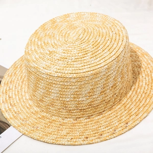 Detailed close-up of a natural wheat straw boater hat with flat top and fine woven texture