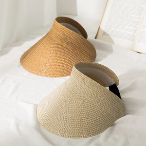 Two stylish straw visors in caramel and beige colors for summer beach sun protection