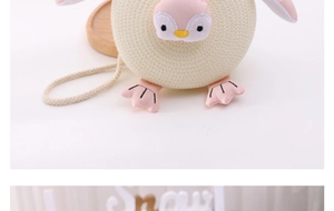 Detailed close-up of a cute penguin-shaped knitted crossbody bag for kids in beige and pink