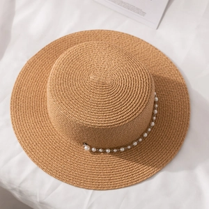 Vue détaillée du chapeau de paille beige à bord plat avec chaîne de perles élégante