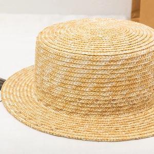 Detailed texture of hand-woven natural straw boater hat with a flat top and stiff brim