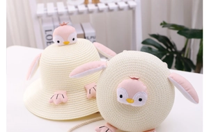 Detail of cute penguin straw hat and matching round crossbody bag for children