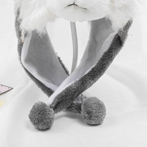 Detailed view of grey and white plush winter hat with soft pom-poms and warm lining