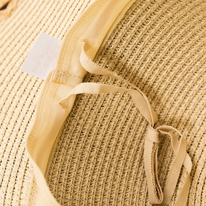Detail view of woven straw hat interior with adjustable strap and breathable sweatband