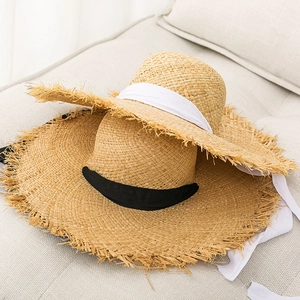 Straw sun hat with wide brim, lace ties and frayed edges for summer beach vacations
