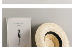 Detail of the fine woven texture and black ribbon of a beige Panama straw sun hat