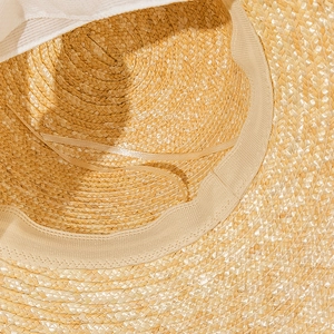 Detailed close-up showing the inner sweatband and adjustable ribbon of the straw sun hat