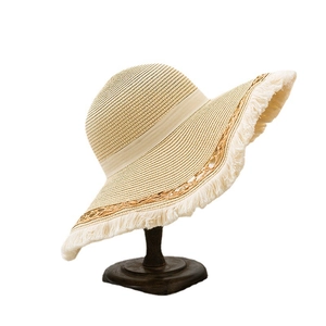 Women straw hat with wide frayed brim and fringe details for beach sun protection
