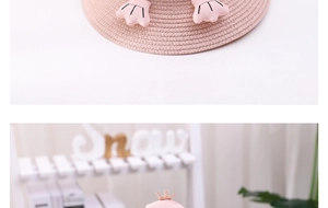 Detail of pink straw hat for girls featuring a cute crown and penguin flipper accents