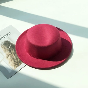Close-up of rose red felt boater hat with reinforced stitching and wool blend texture
