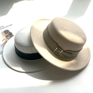 Close-up of beige and white wool felt boater hats with chic leather belts and metal buckles