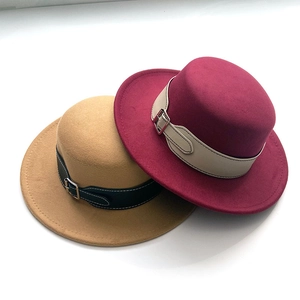 Close-up of wool fedora hats in burgundy and camel with decorative leather belts