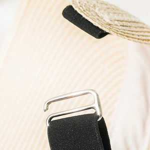 Detail of adjustable black elastic strap with silver metal hook on woven straw hat