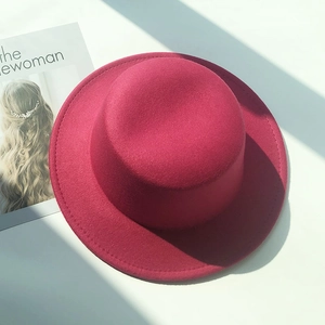 Close-up of rose red wool felt flat top hat with premium stitching and texture