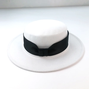 Detail view of white wool boater hat with a wide black grosgrain ribbon and flat top design