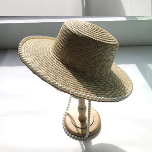Elegant straw sun hat with wide brim and pearl edges for women perfect for summer beach travel