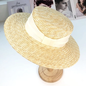 Détail d'un chapeau de paille à bord large avec un élégant ruban en satin crème