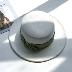 Detailed close-up of a white flat top wool felt hat with khaki leather belt and silver buckle