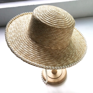 Elegant wide brim straw sun hat with pearl trim and long pearl chain for women