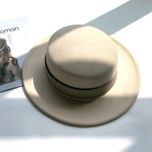 Detailed close-up of a French style beige wool felt boater hat with dark brown leather strap