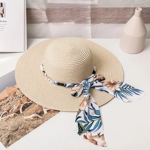 Vue détaillée d'un chapeau de paille à large bord avec ruban floral élégant en boucle