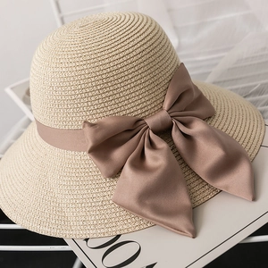 Close-up of the woven paper straw texture and large brown satin bow on the sun hat