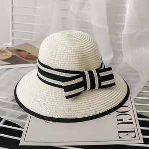 Elegant women's straw sun hat with black and white striped ribbon and side bow detail