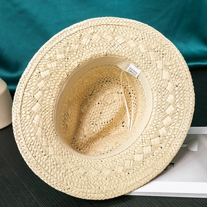 Detail of inner sweatband and 100% paper fiber weave on a beige straw fedora hat