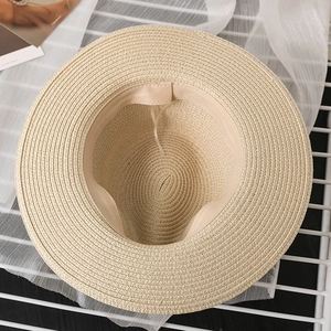 Detail view of the interior adjustable strap and woven texture on a straw sun hat