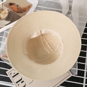 Close-up of wide brim straw sun hat showing fine weave texture and sweatband inside