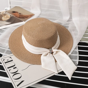 Flat top straw boater hat featuring a white chiffon ribbon and sparkling rhinestone buckle