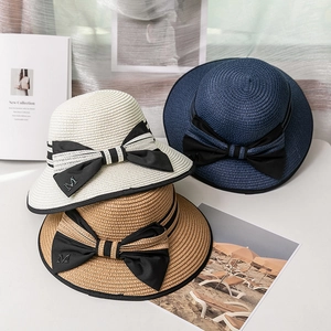 Trois chapeaux de soleil en paille rayée avec grands nœuds et breloque M pour les vacances