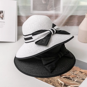Chapeau de soleil en paille avec nœud et lettre M pour vacances d'été à la plage