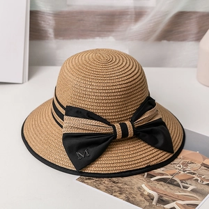 Détail du chapeau de paille avec ruban gros-grain noir et emblème métallique M