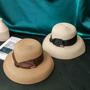 Elegant wide brim straw sun hats in tan and beige colors with satin ribbon decoration