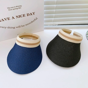 Detail showing two wide-brim woven straw sun hats in navy and black with striped bands