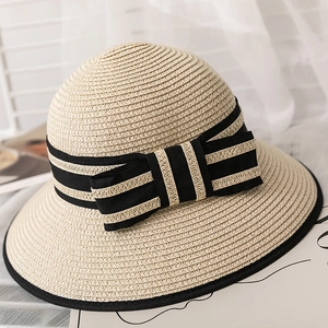 Detail of summer straw sun hat with striped bow and black trimmed edge for women