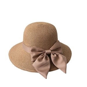 Brown woven straw hat with large satin bow for sun protection in classic wide-brim design