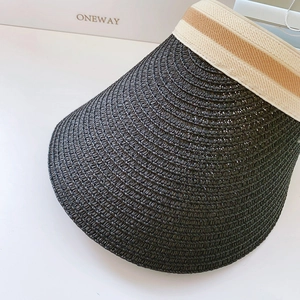 Close-up of woven black straw texture and striped ribbon detail on sun visor hat