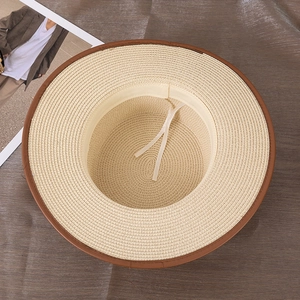 Détail du chapeau de paille montrant le tissage fin et le cordon de serrage blanc réglable