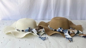 Détail de chapeaux de paille tressée avec perles et rubans de soie à motifs floraux