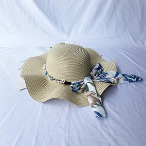 Women's wide brim straw sun hat with wave edge, floral ribbon and pearl strap details