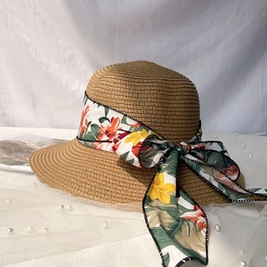 Détail du chapeau de paille pour femme avec ruban floral et grand nœud élégant