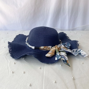 Chapeau de soleil bleu marine à bord ondulé avec perles et ruban floral tropical