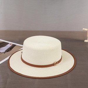 Détail d'un chapeau de paille à haut plat avec bande en cuir brun et boucle dorée