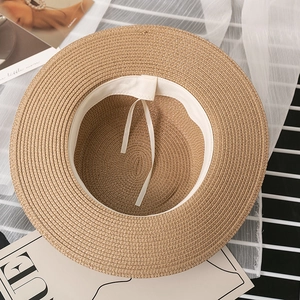 Detail of the woven straw hat interior featuring white sweatband and adjustable drawstring