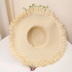 Detail of wide brim straw hat with fringe edge and adjustable interior white string